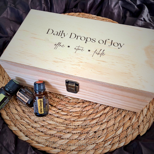 Eine Aromatherapie-Diffuser und verschiedene ätherische Öle auf einem Baumstumpf.