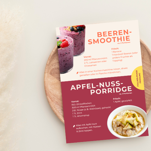 Rezeptkarte für Beeren-Smoothie und Apfel-Nuss-Porridge auf einem Holzbrett.
